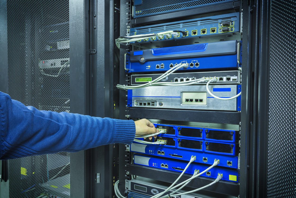 A man fixing a network patchwork IT Professional connecting fibre channel network cables