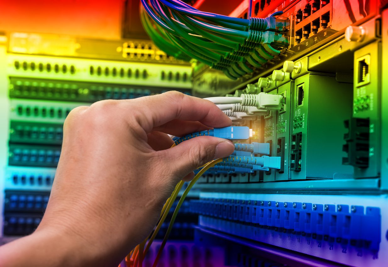 man working in fiber optic network server room with network hub MEINTENANCE